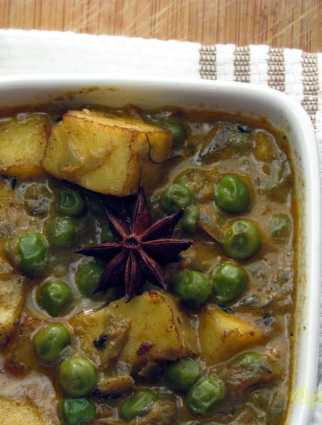 Mutter paneer masala in a white bowl with garnishing.