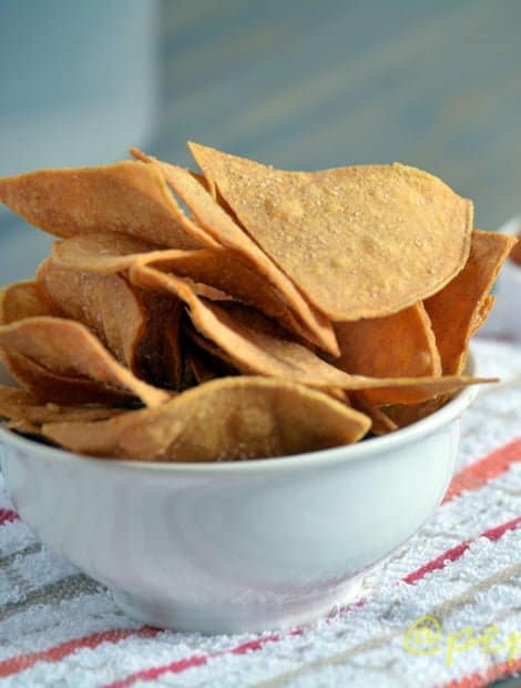 Spicy tortilla chips served in a white bowl.