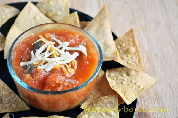 spicy homemade jalapeno salsa is kept in a bowl along with tortilla chips.