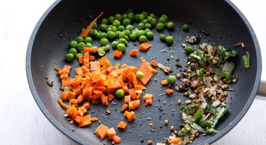 adding chopped vegetables to poha upma