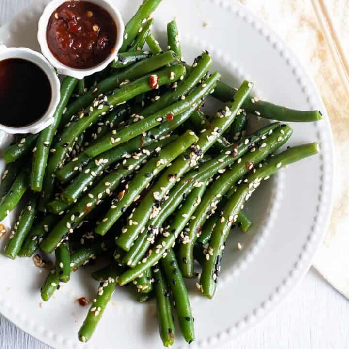 Chinese green bean stir fry served with soy sauce and sriracha sauce