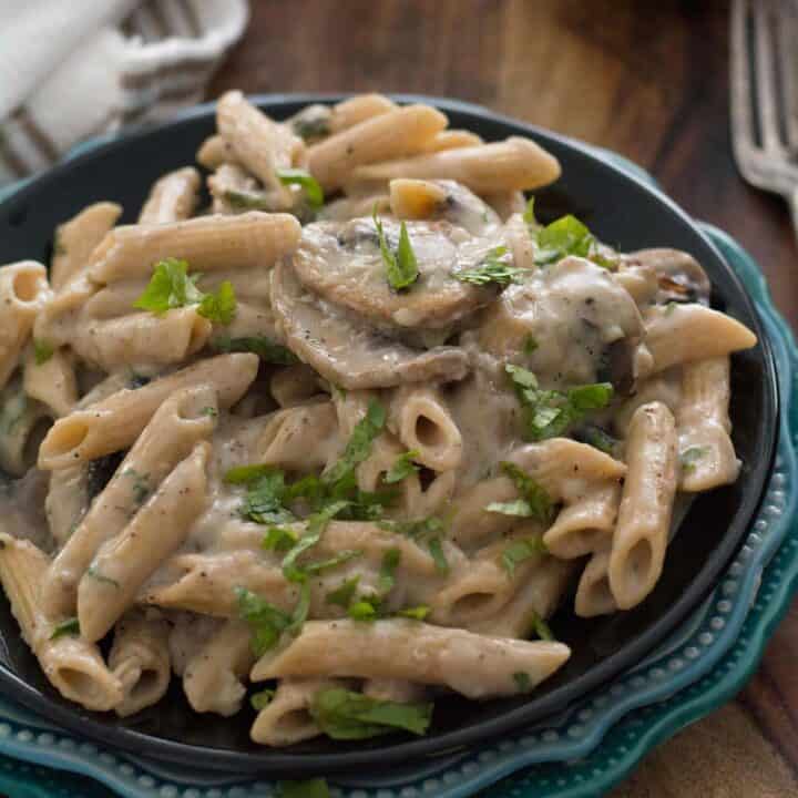 Pasta with mushroom sauce placed in black plate