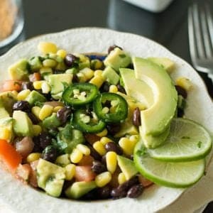 Black bean corn avocado salad lime cilantro dressing, a bright refreshing salad for serving as a side or appetizer. A great effortless addition for weeknight dinners or for game days. A paleo, gluten free and low carb dish made with vegetables and beans.