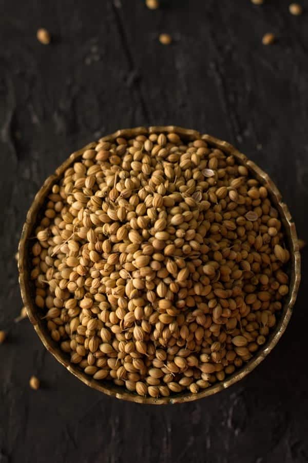 Coriander seeds in a bowl, which is one of the essential ingredients that you find in the Indian cooking especially in the South Indian cooking. The leaves are consumed as herb and the seeds as spices.