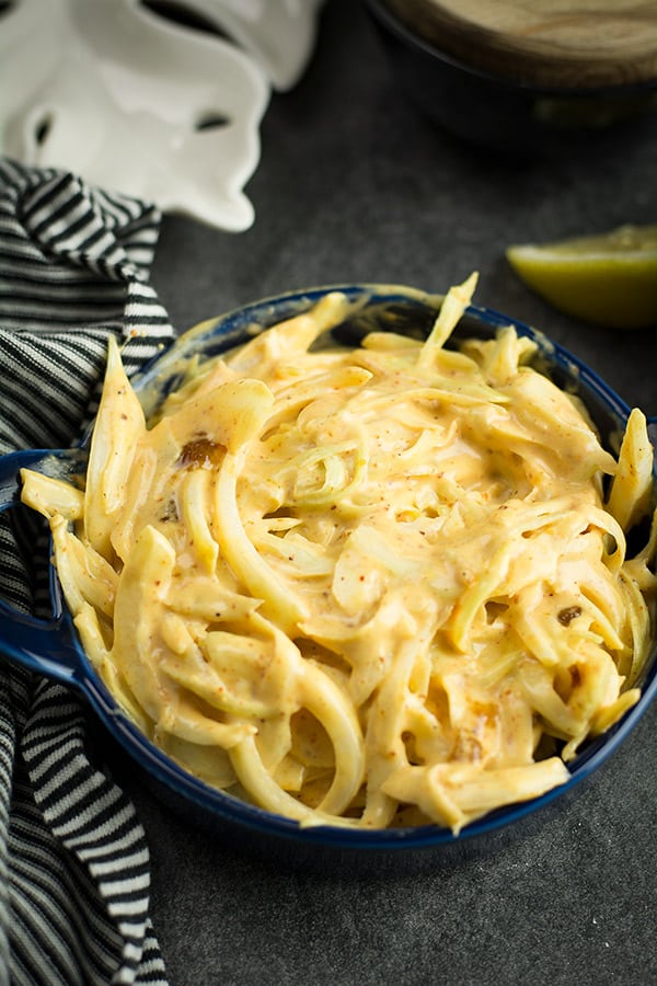 The spicy creamy coleslaw kept in a blue bowl for servings as a dip or as a topping for the sandwich or with grilled meat.