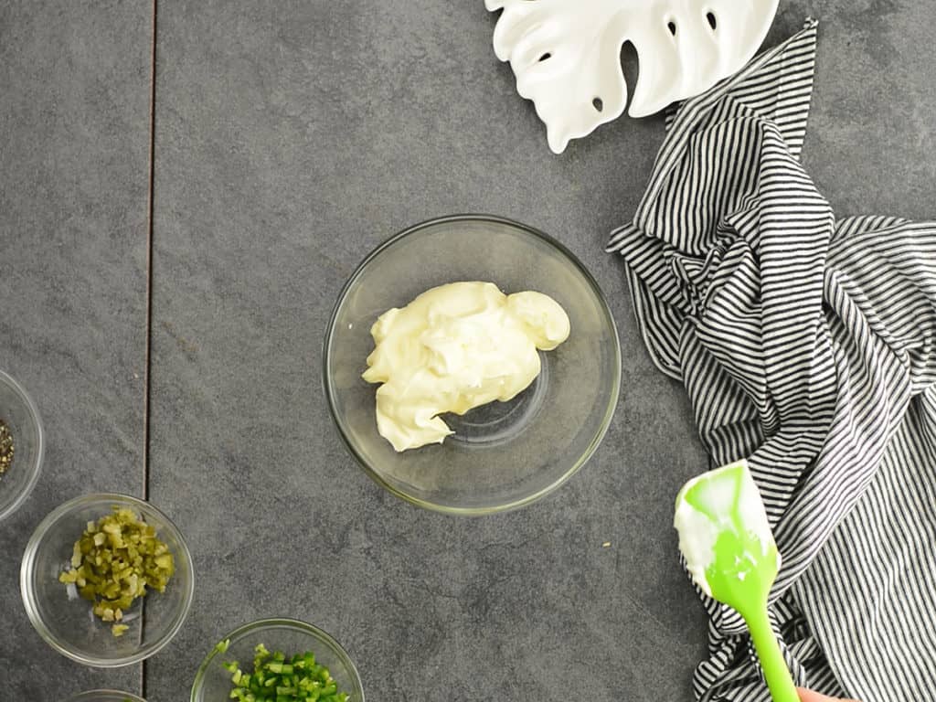 adding mayo in glass bowl for making aioli  sauce.