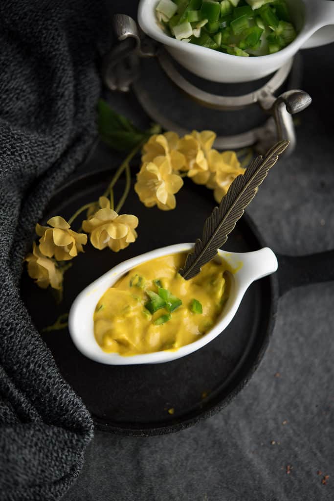 This hot jalapeno mustard sauce is served in a single serving small white bowl.