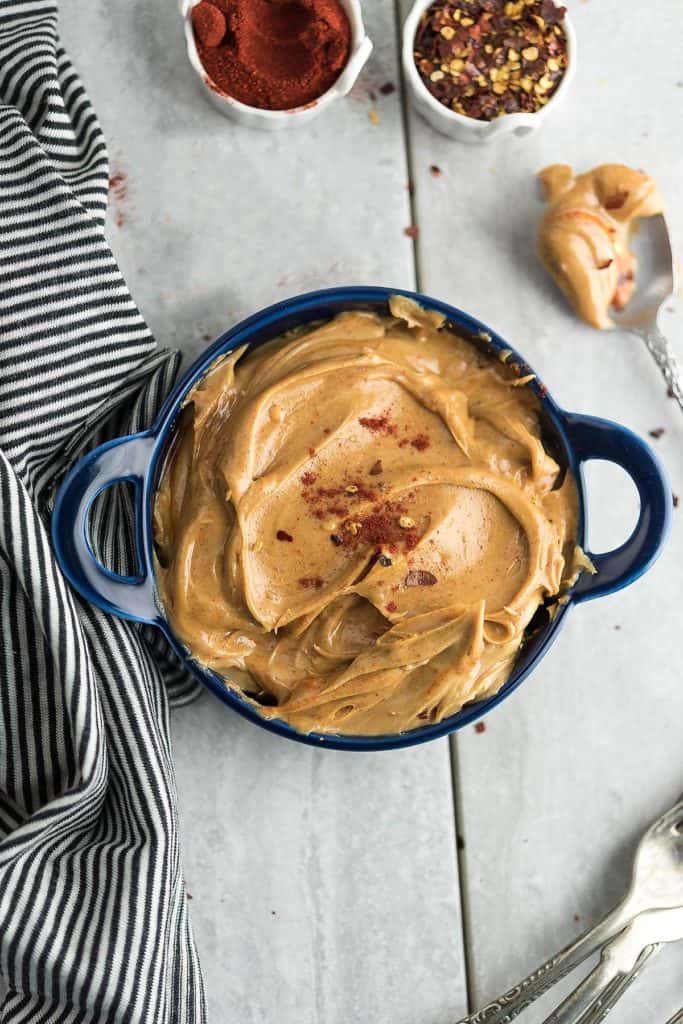 Hot and spicy peanut butter in a blue decorative bowl in a marble slab.