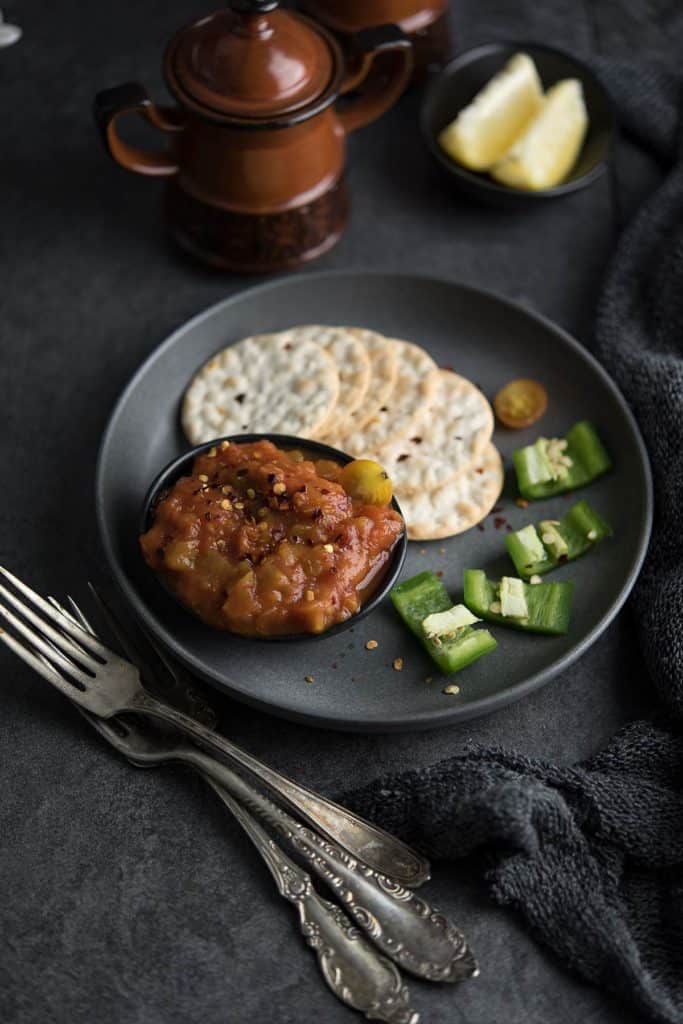 spicy roasted jalapeno and tomato salsa served in a black dipping bowl.