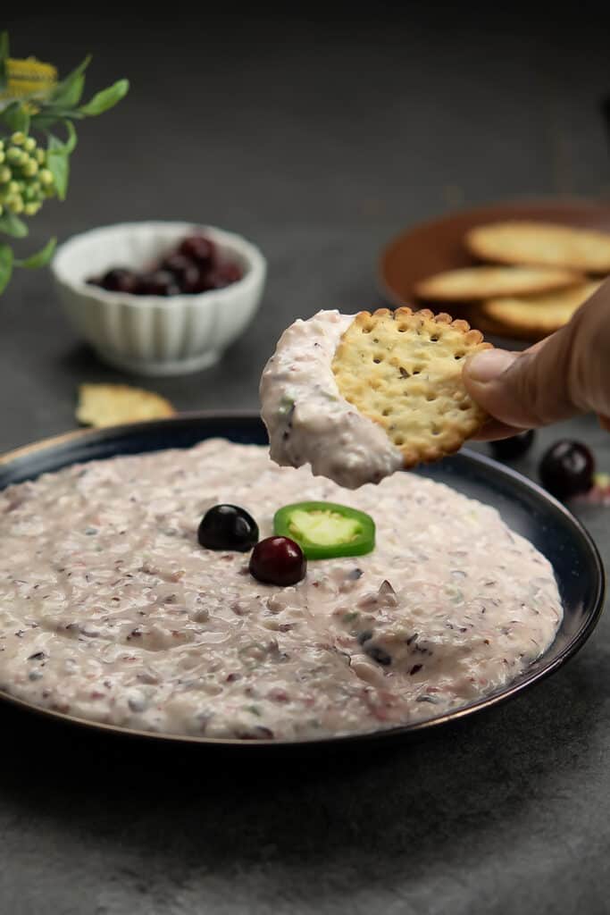 The cracker dipped in the cranberry jalapeno dip