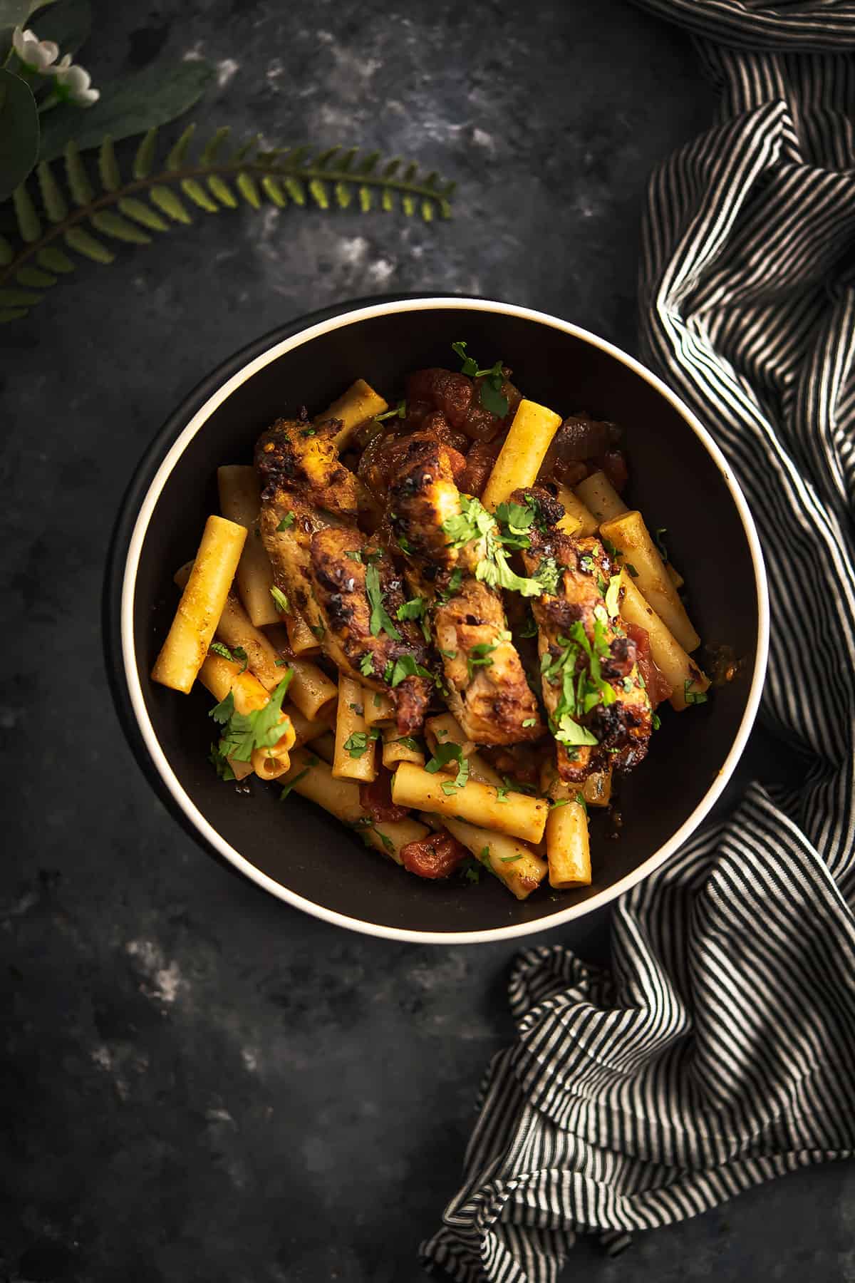 spicy chicken pasta placed in a black bowl