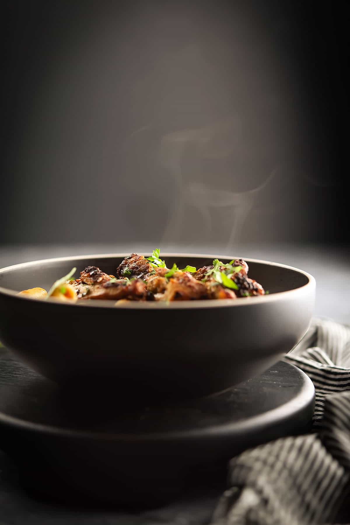 steaming hot chicken pasta in a black bowl