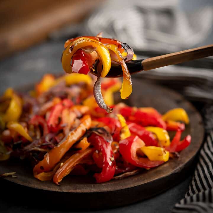 This oven roasted peppers and onions recipe is ready in less than 25 minutes. It's a versatile dish to serve as a topping or as a side dish.