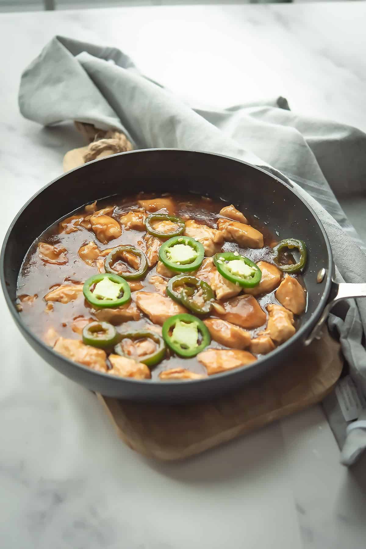 Chinese chicken made with jalapeno slices served in a pan 