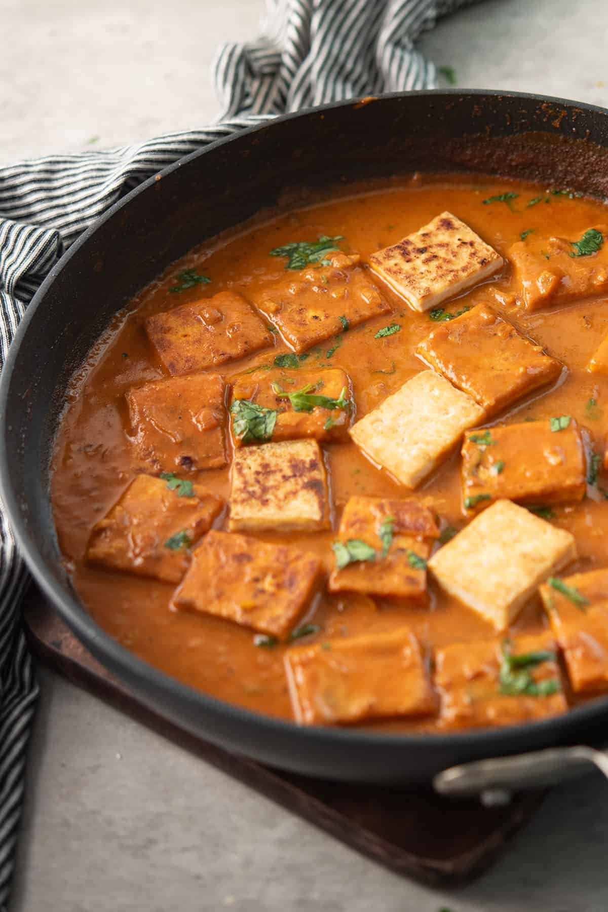 tofu curry in a pan with creamy tomato based curry