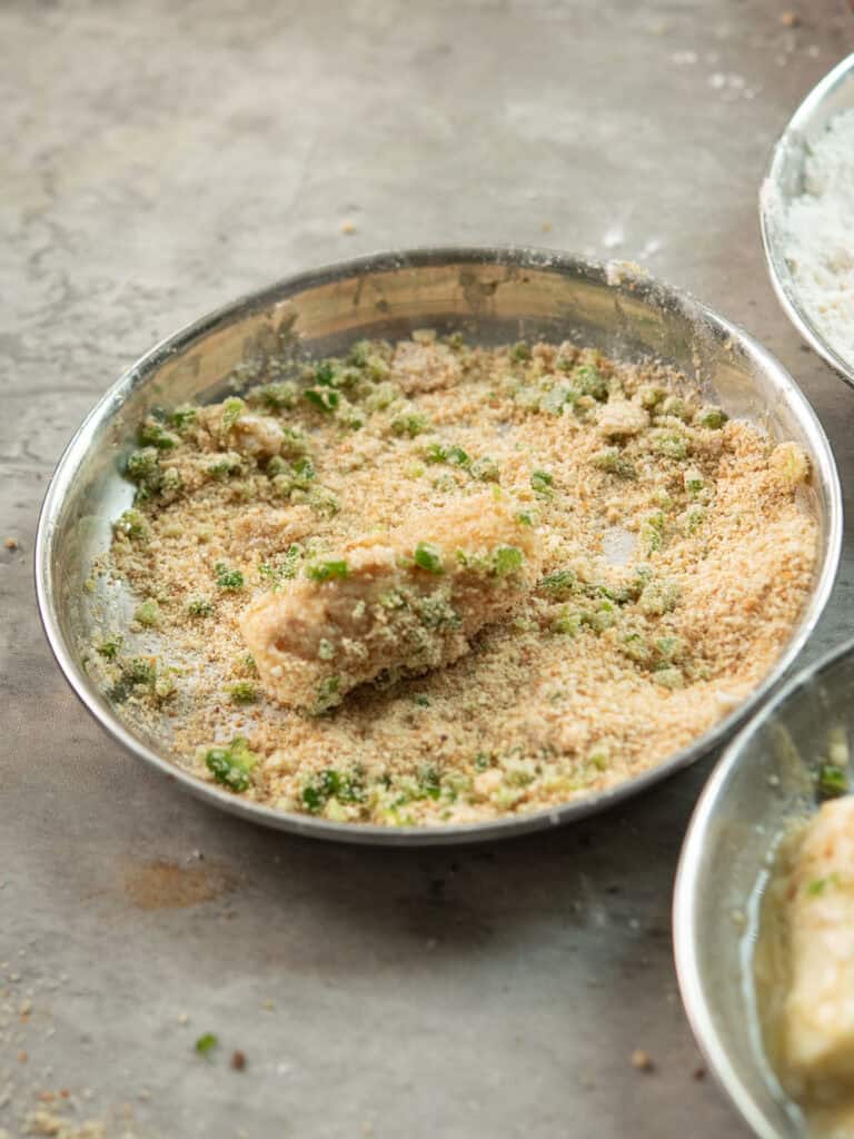 step 3: tossing the cheese sticks into the bread crumbs for making Jalapeno Cheese Sticks