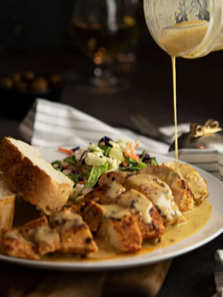 cajun chicken breast served with the spicy sauce, salad, and with bread