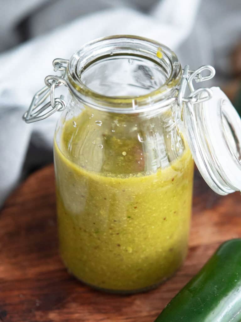 jalapeno hot sauce stored in a glass container with a airtight lid