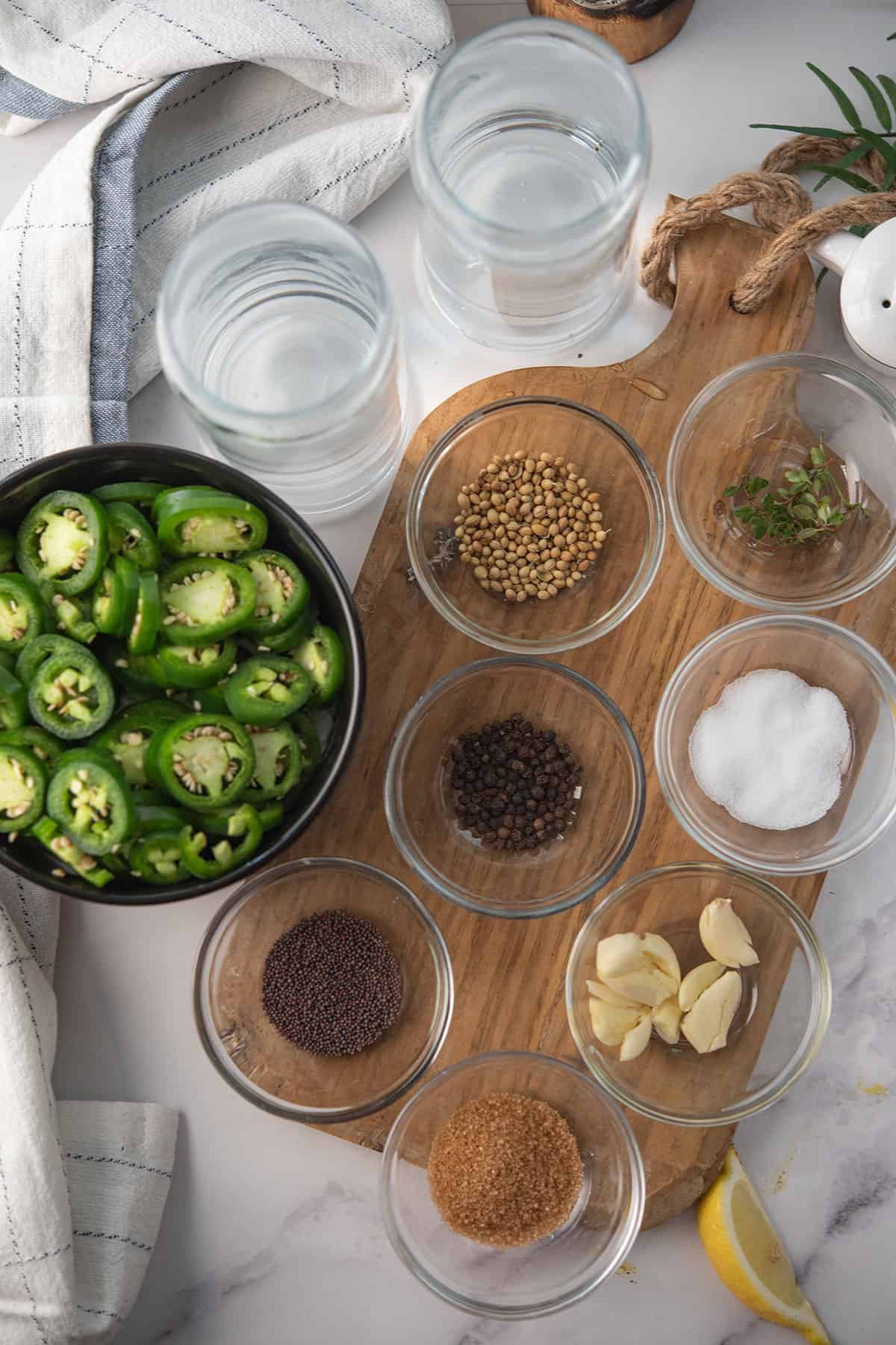 ingredients for pickled jalapeno assembled over wooden board