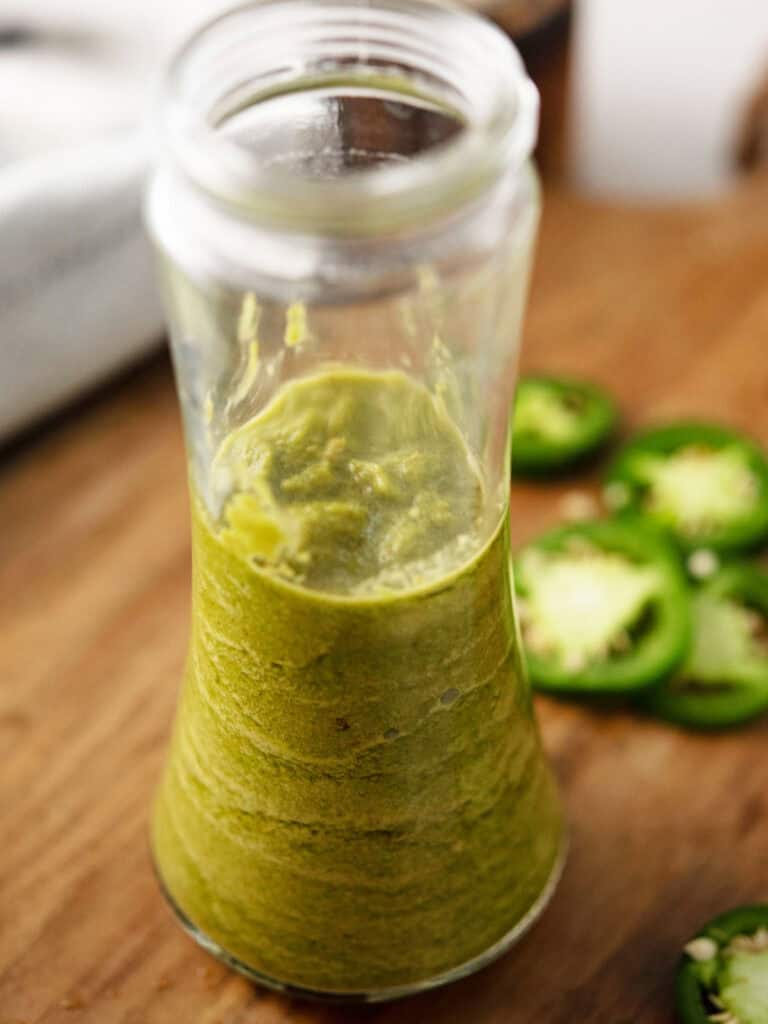 jalapeño marinade stored in glass jar with jalapeno slices