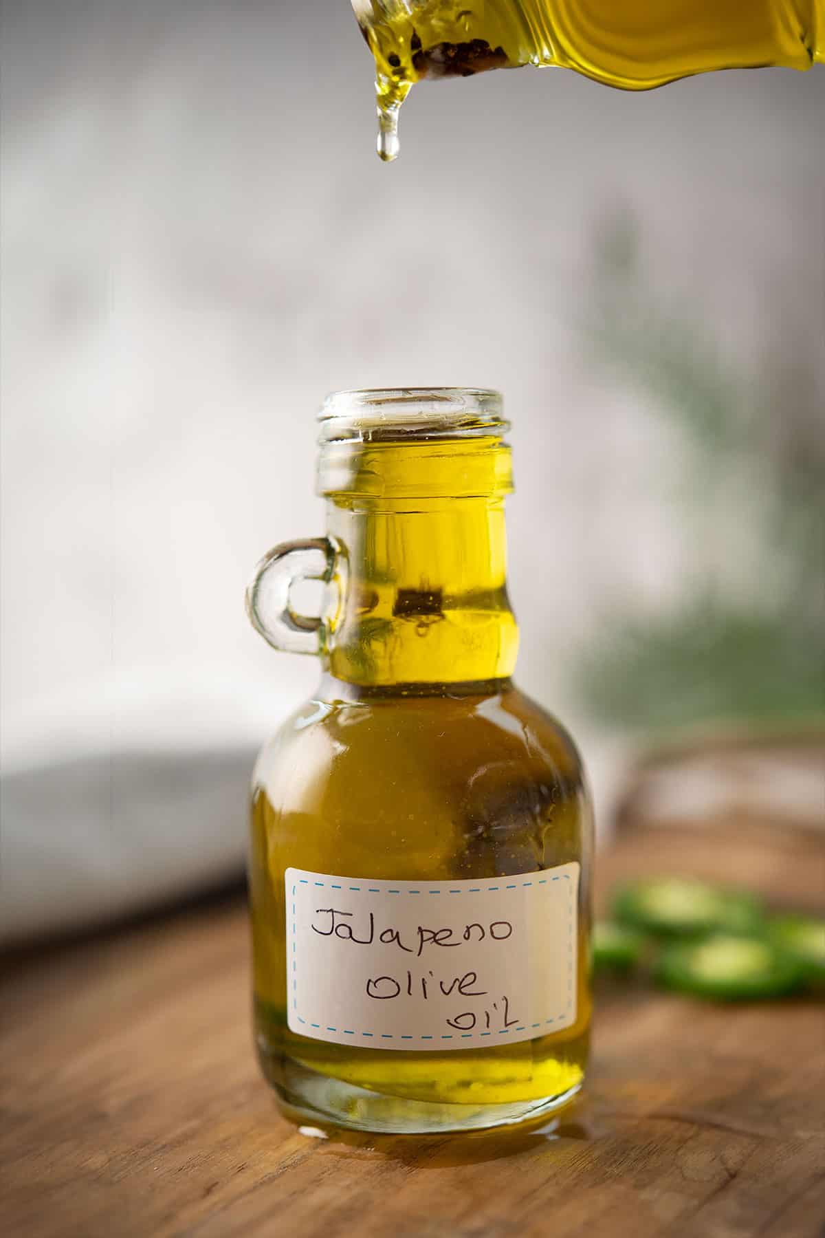 jalapeno olive oil stored in a decorative glass jar