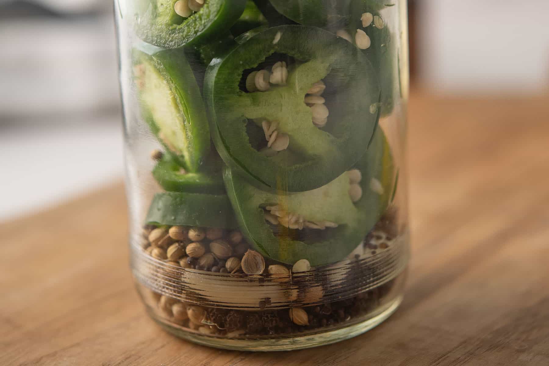 jalapeno sliced packed in a glass jar for pickling