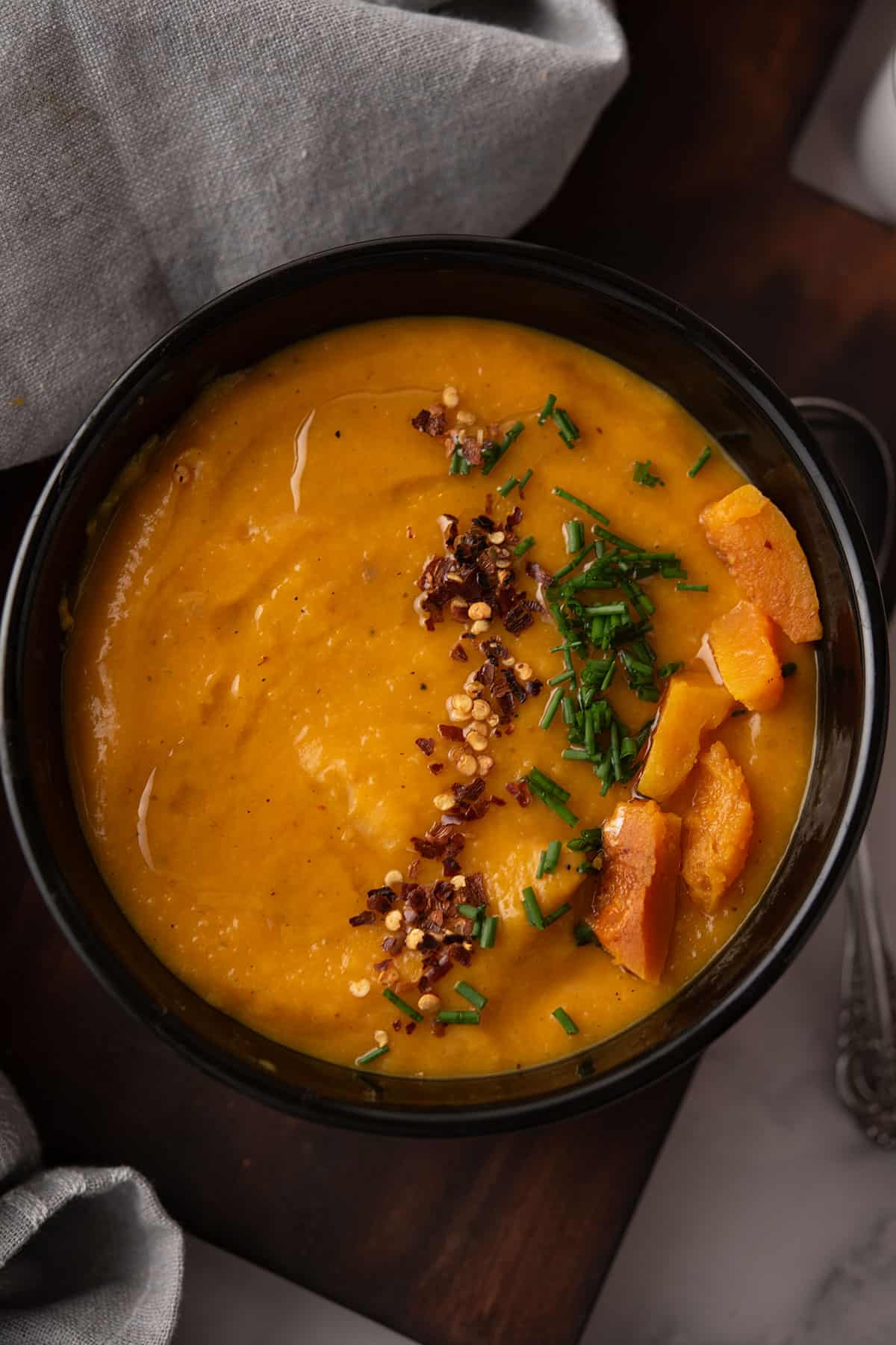 spicy butternut squash soup served in a black bowl