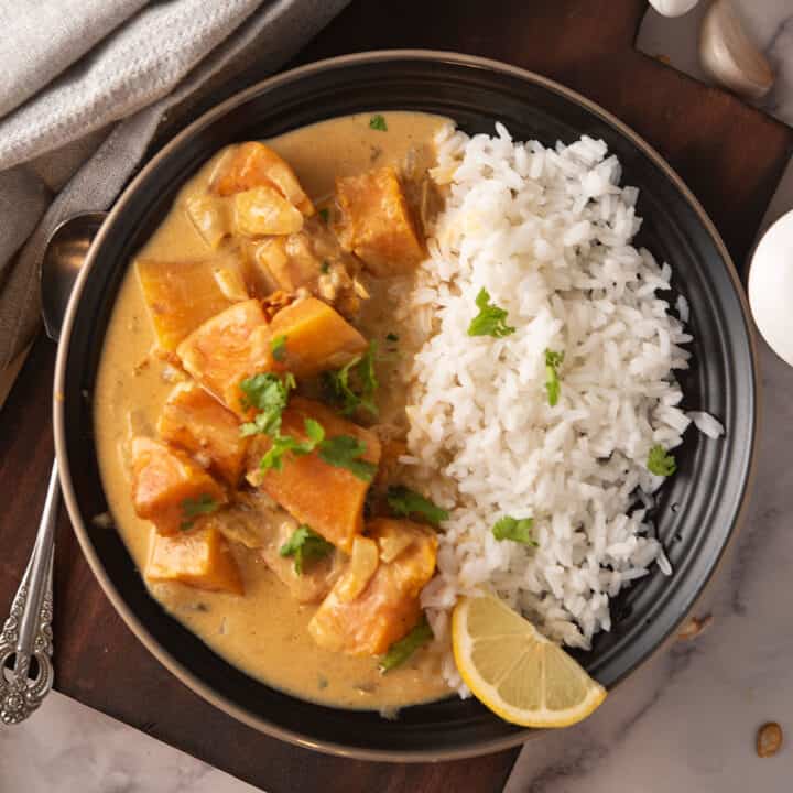 butternut squash curry served in a dinner plate with rice
