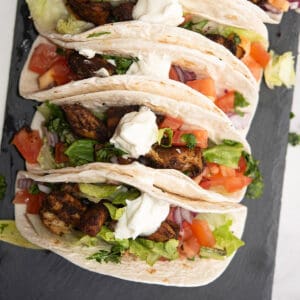 blackened mahi mahi tacos served over a plate