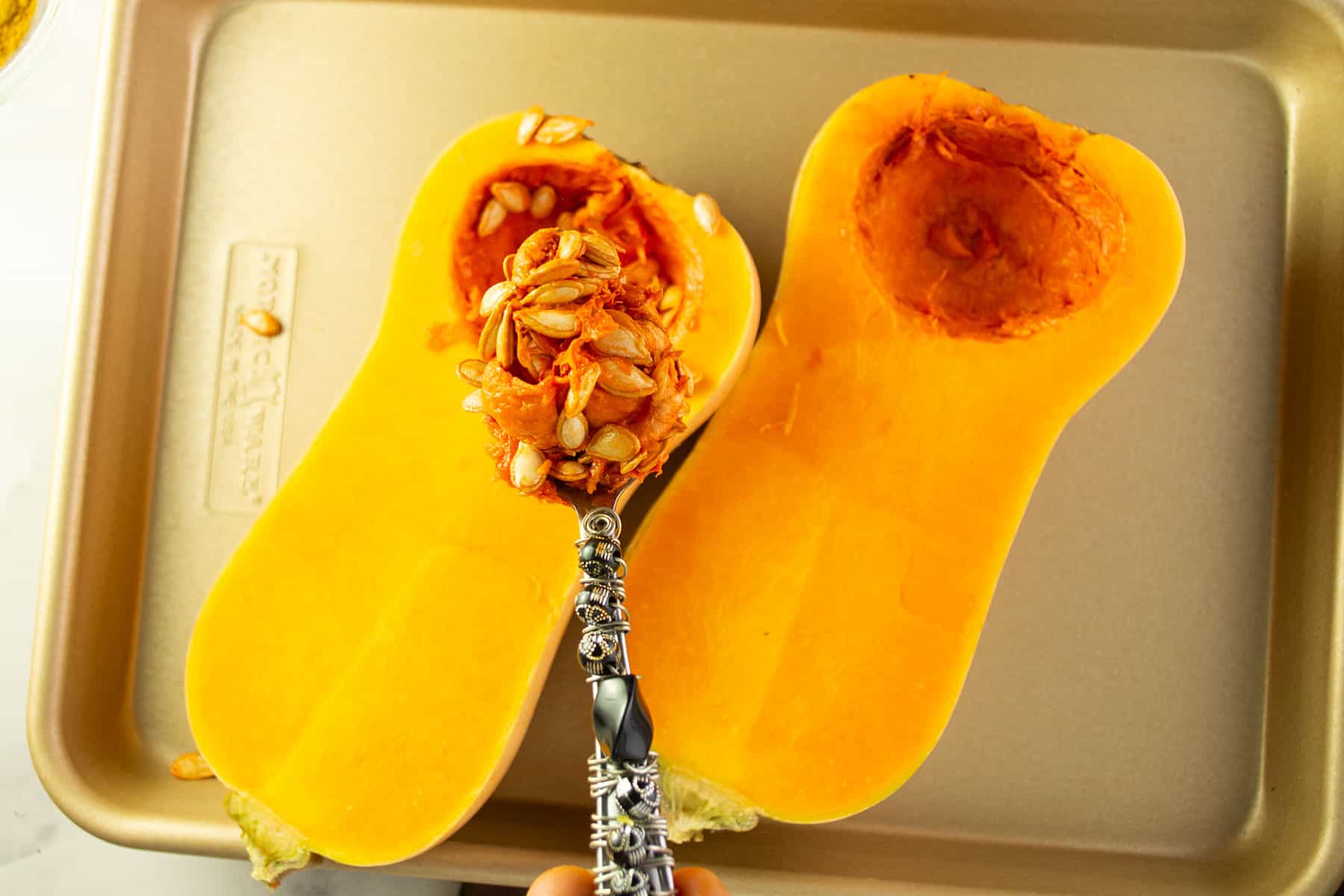 scooping the seeds of butternut squash