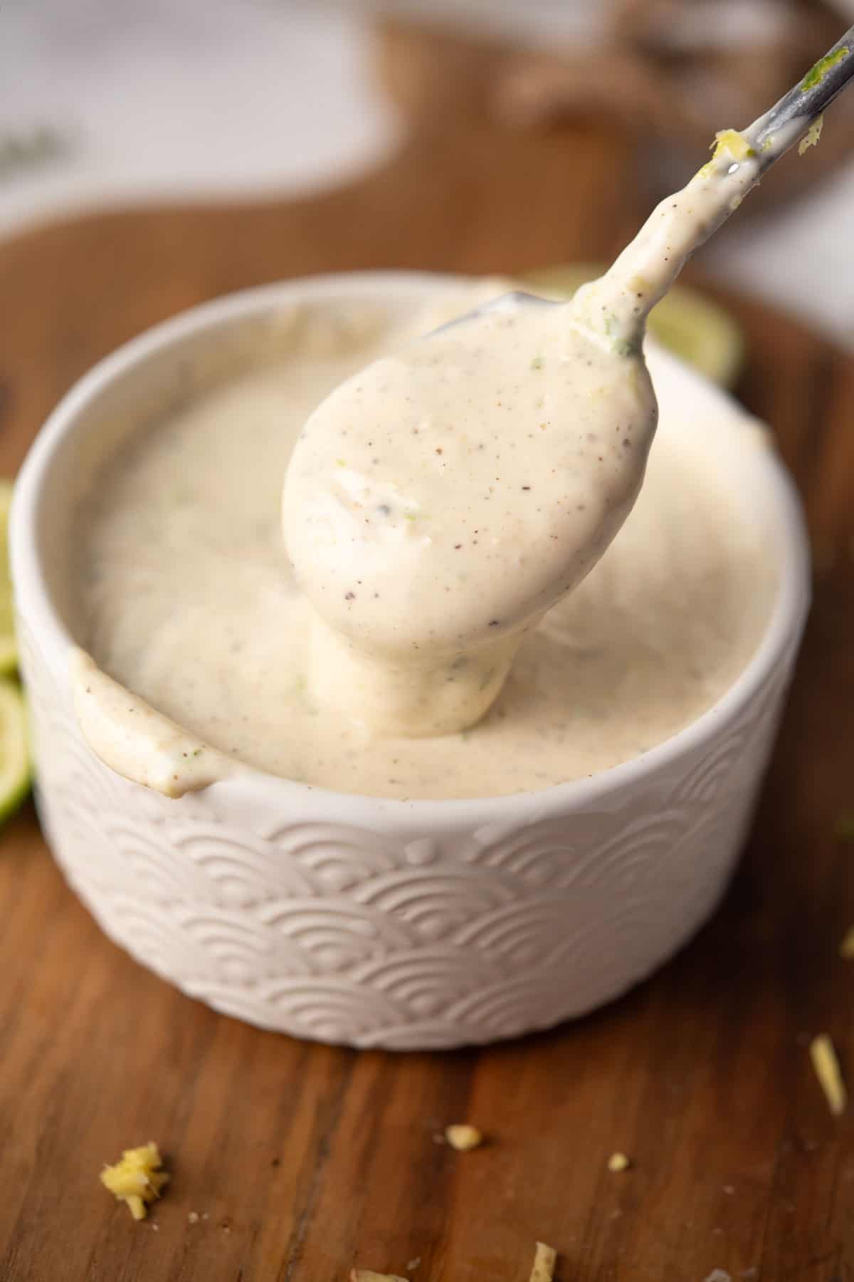 creamy and delicious ginger lime aioli sauce dripping in a spoon.