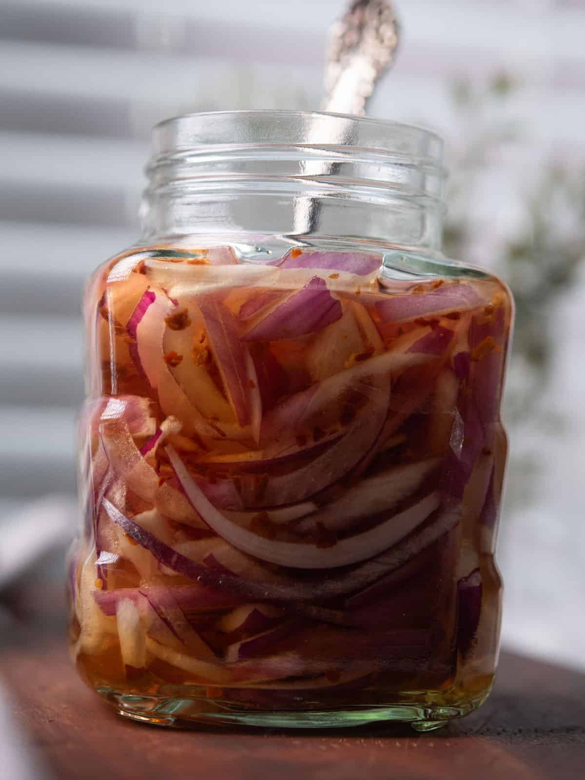 spicy pickled onion in a glass jar with fork