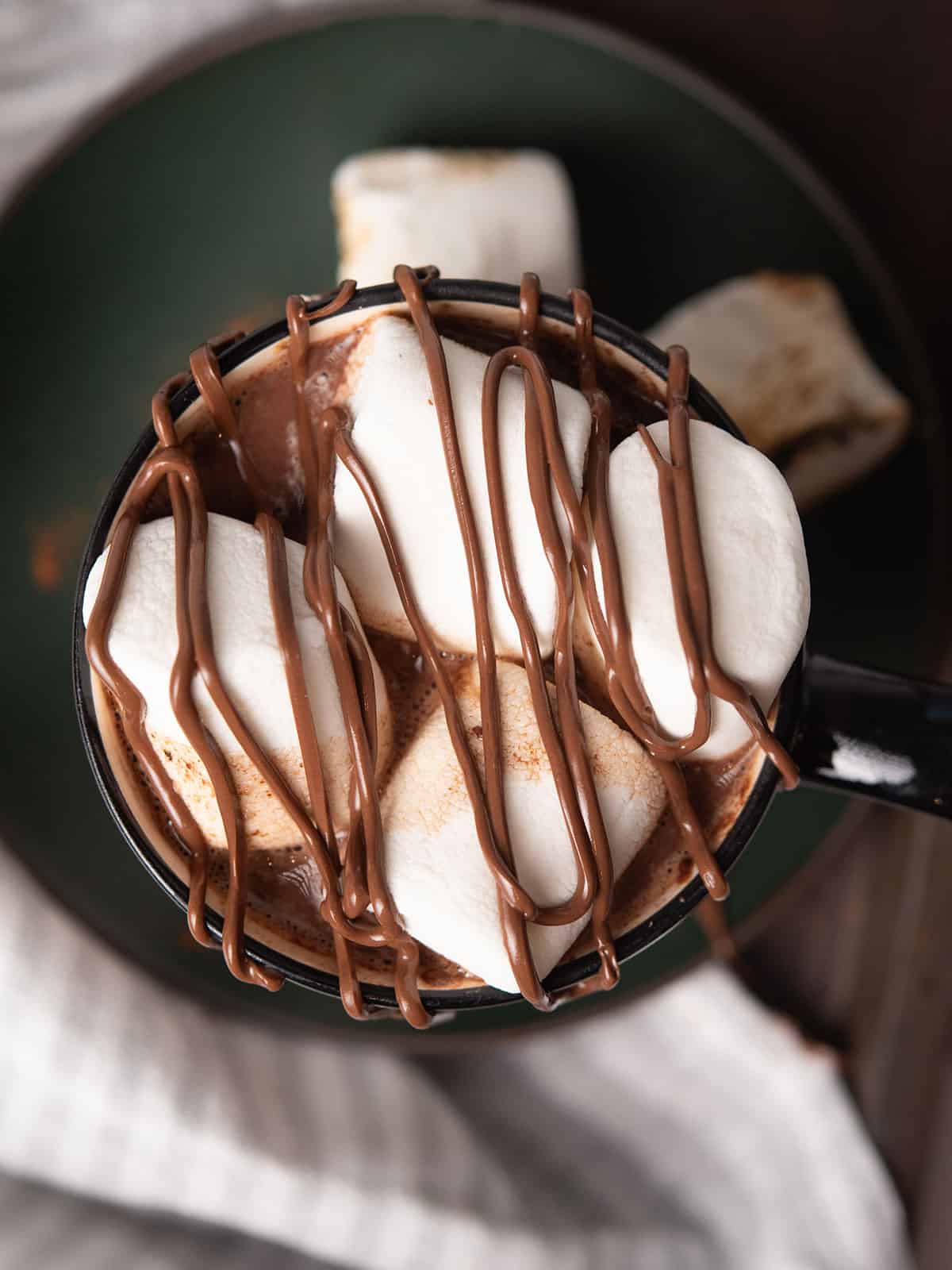 chocolate drizzled over marhsmellow topped on Cajun hot chocolate