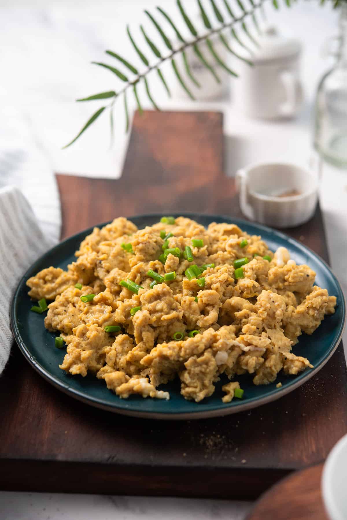 cajun scrambled eggs served in a plate with spices on the side