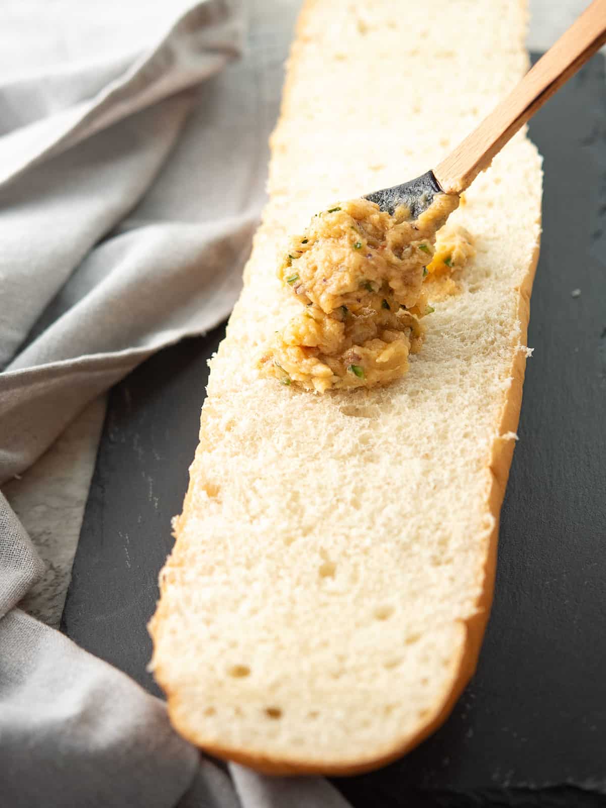 the jalapeno infused sauce is spread over the bread load with a spoon
