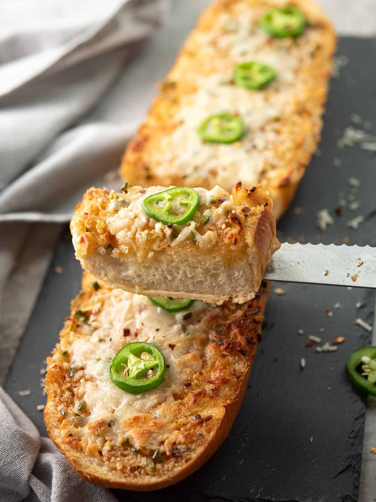a slice of jalapeno garlic bread lifted with a knife