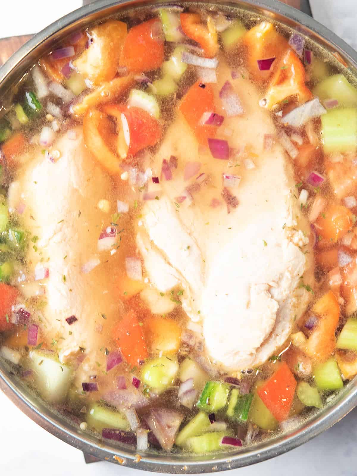 toss all the ingredients to the pan for making spicy chicken soup
