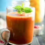 red, spicy marinara sauce in the glass bottle with basil leaves.