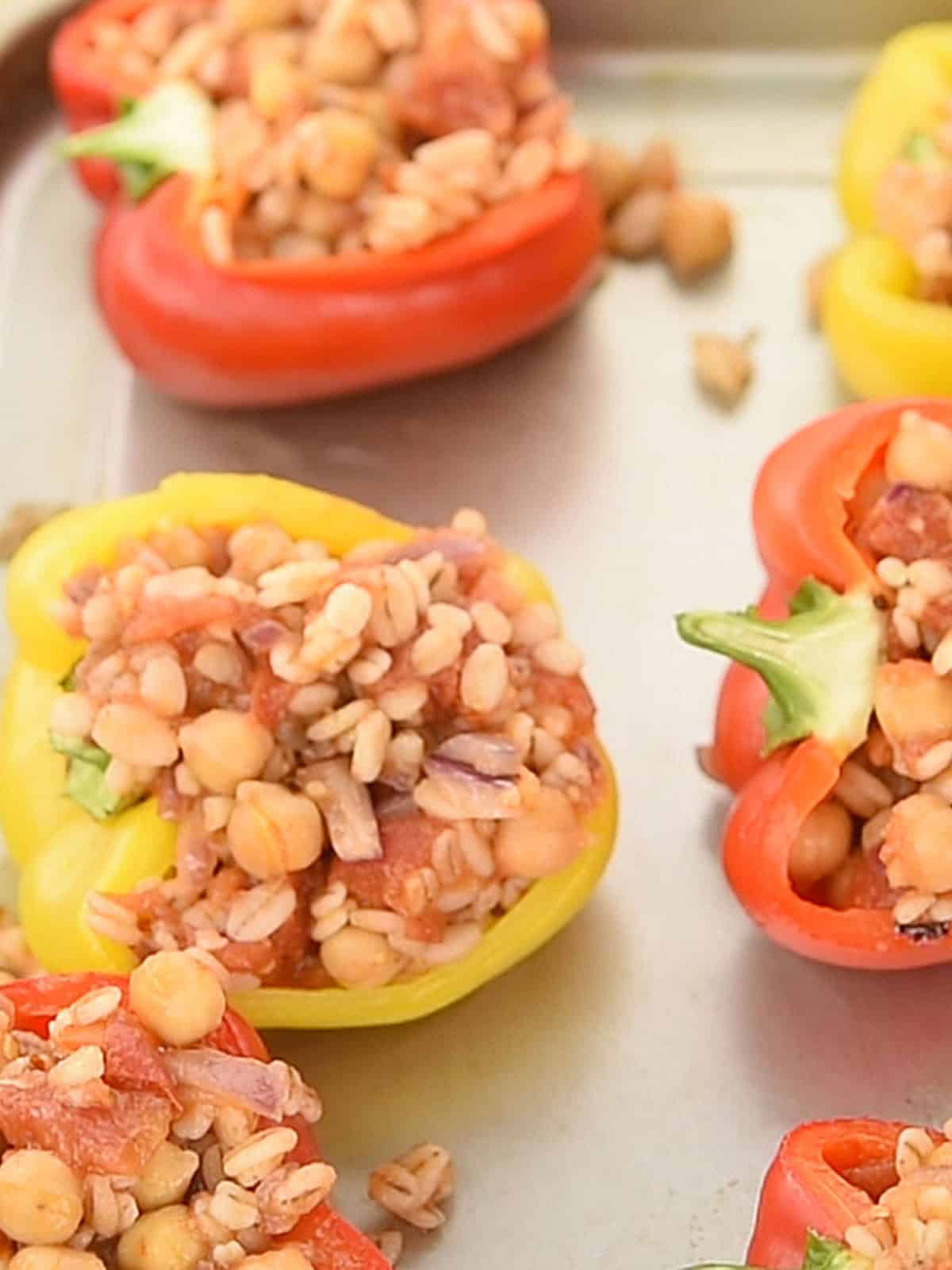 Filling the blanched bell peppers with the cooked barley mixture before baking.