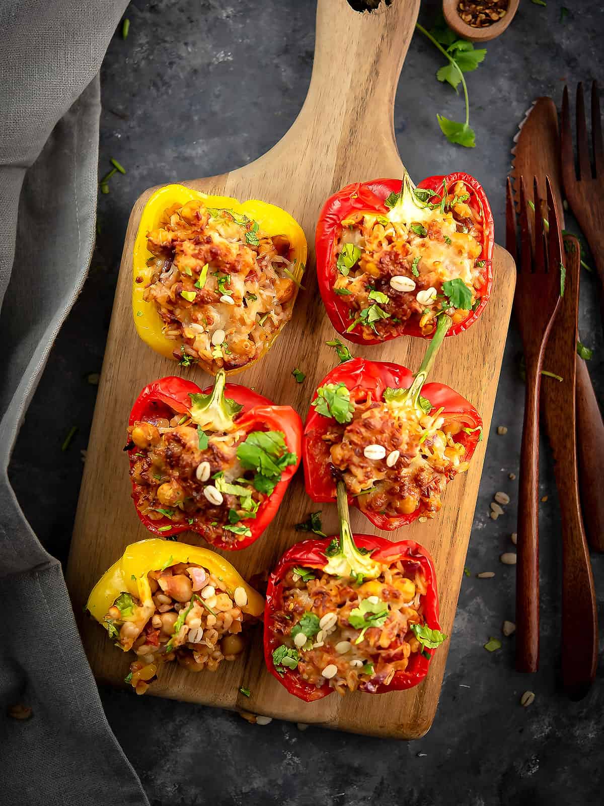 Barley stuffed peppers served on a white plate with garnished parsley.