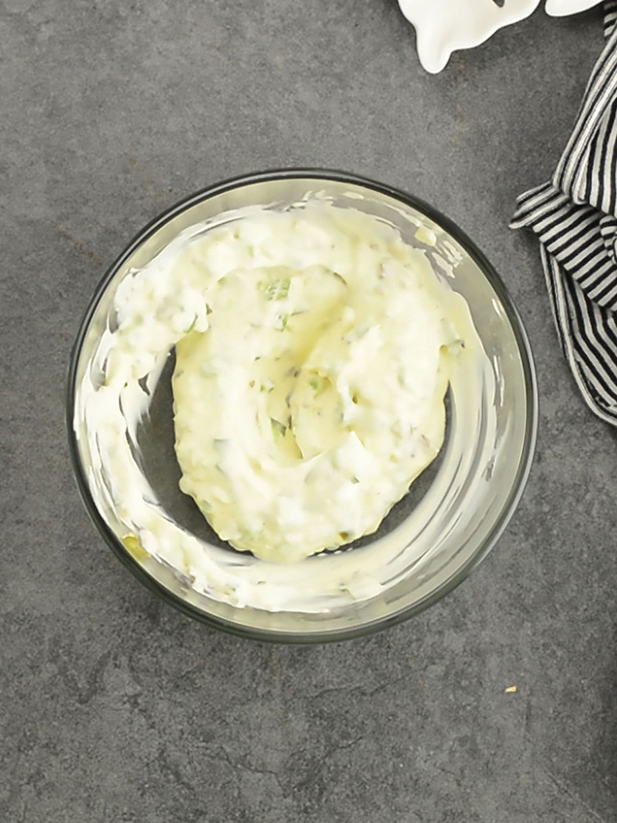 Mixing bowl with mayonnaise, minced jalapeno, and garlic preparing jalapeno aioli.