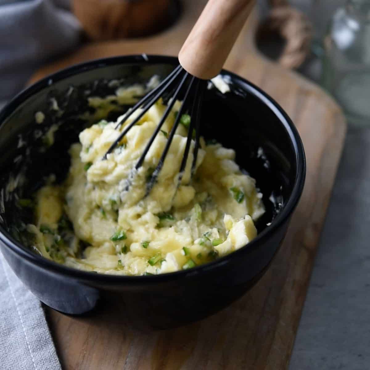 Whisk mixing ingredients for jalapeno honey butter in a bowl.