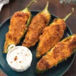 jalapeno cheddar poppers in a plate with a white dipping sauce