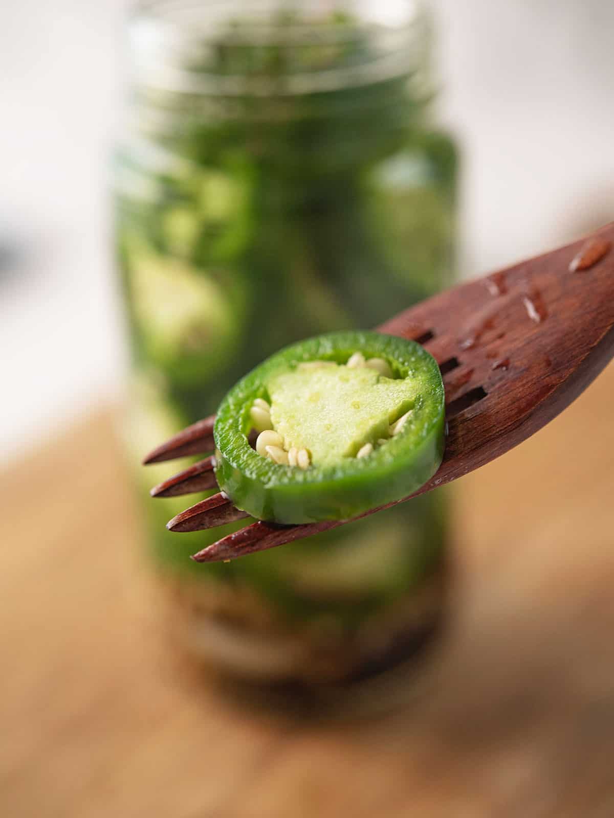 Close-up of sliced pickled jalapeños with a fork