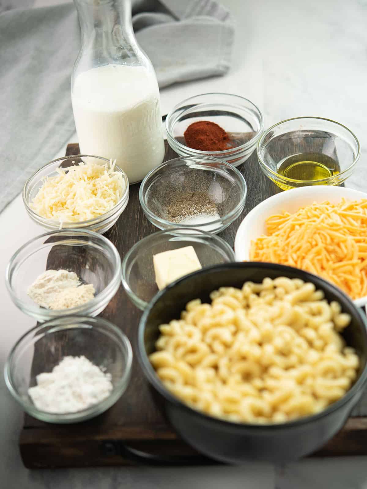 Ingredients for spicy mac and cheese including pasta, cheese, and spices.