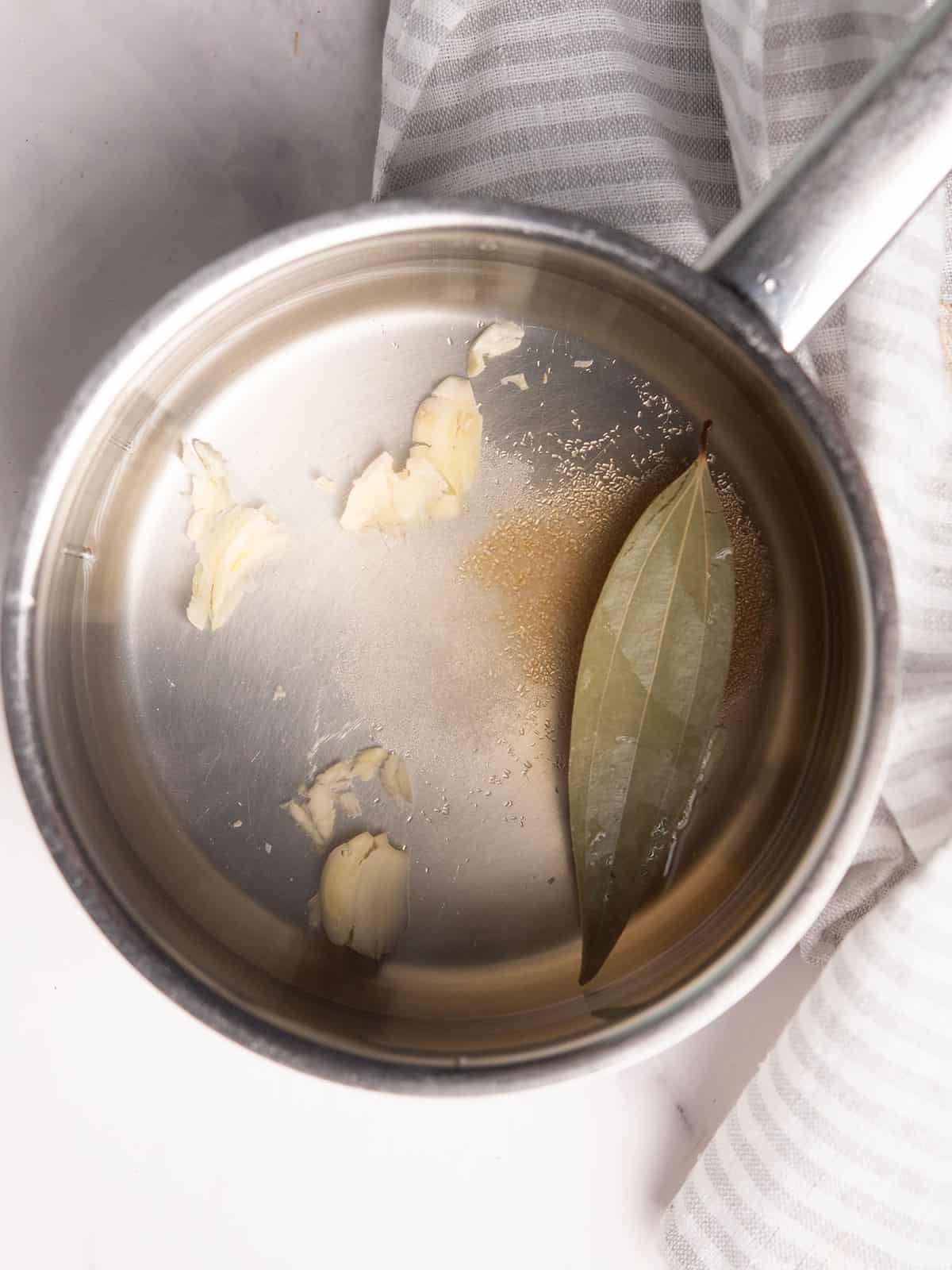 Vinegar and spices boiling in a saucepan to create the pickling brine.