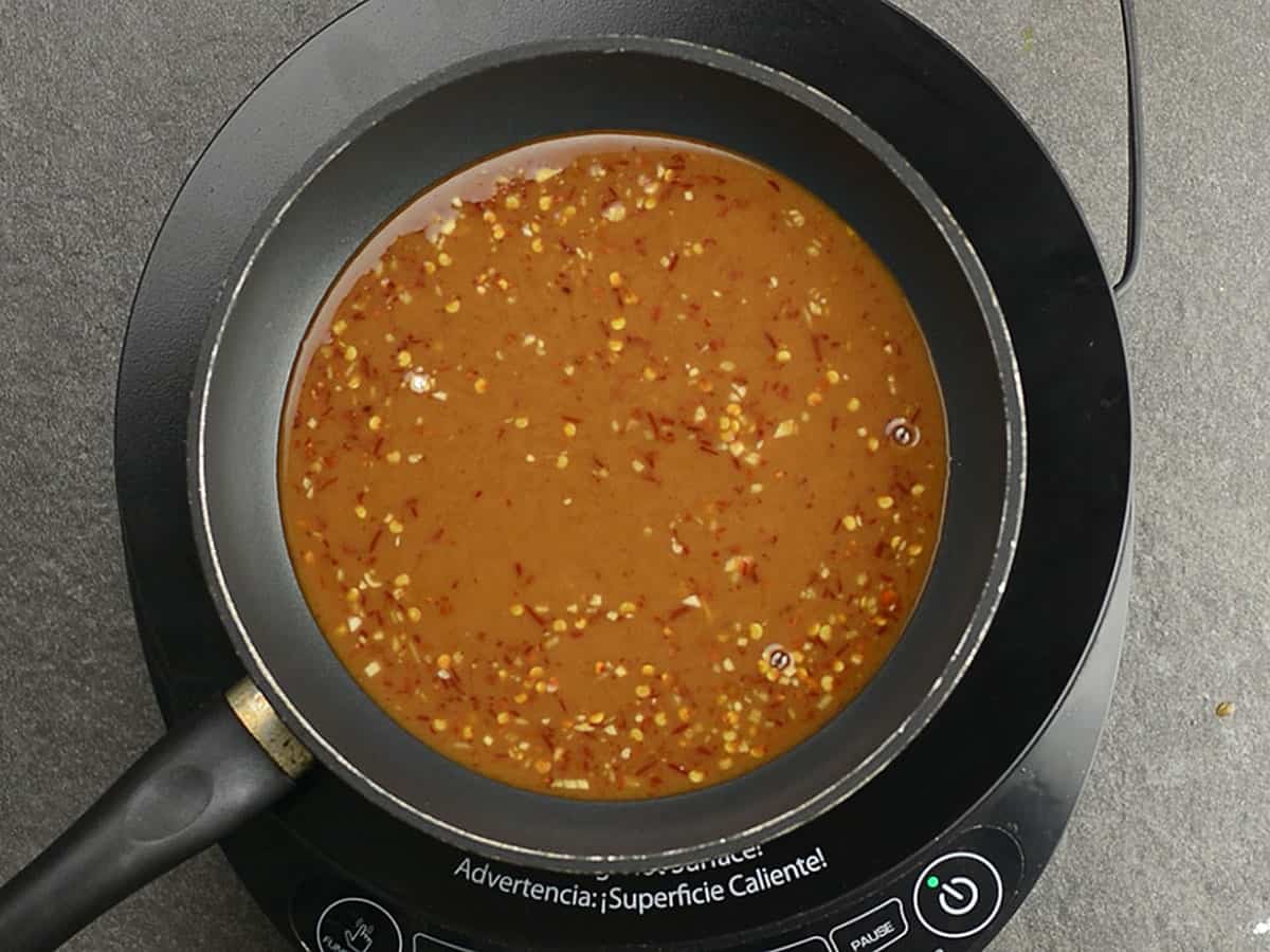 Sauce mixture bubbling in a saucepan on the stove