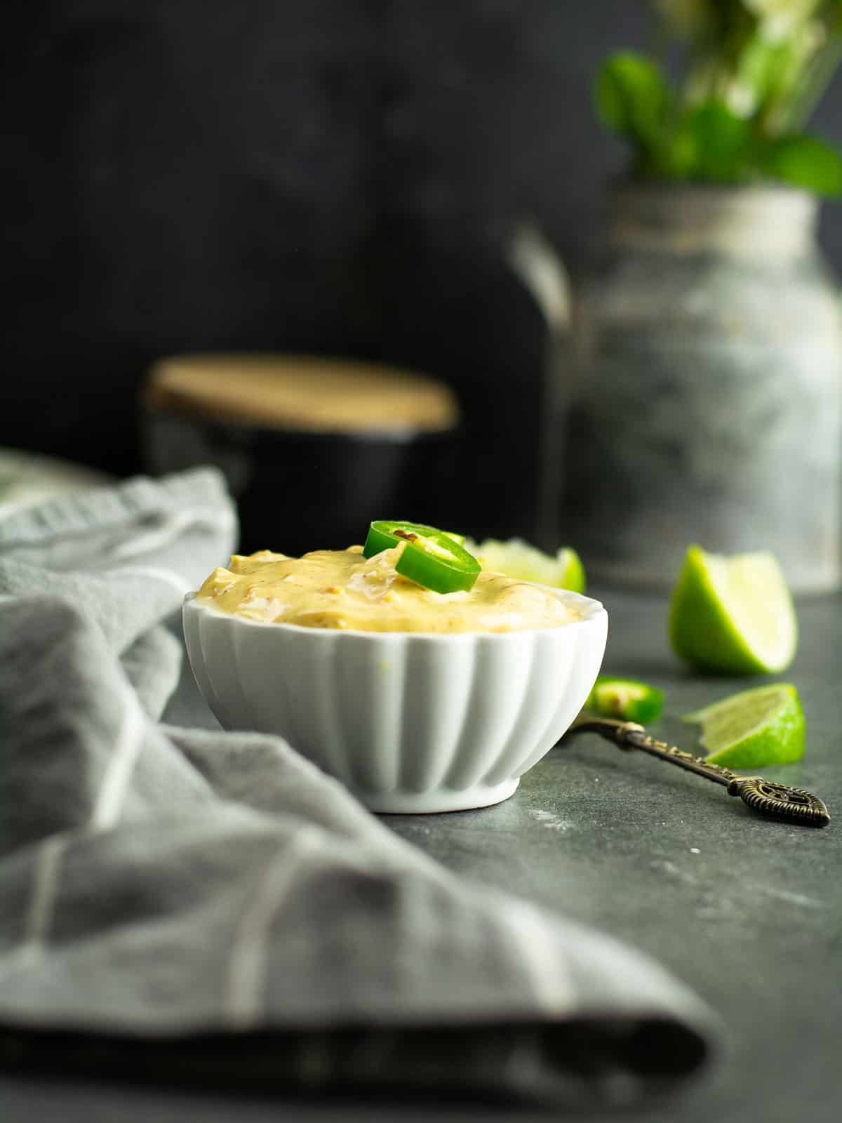 Cajun aioli served in a small bowl with fresh ingredients around.