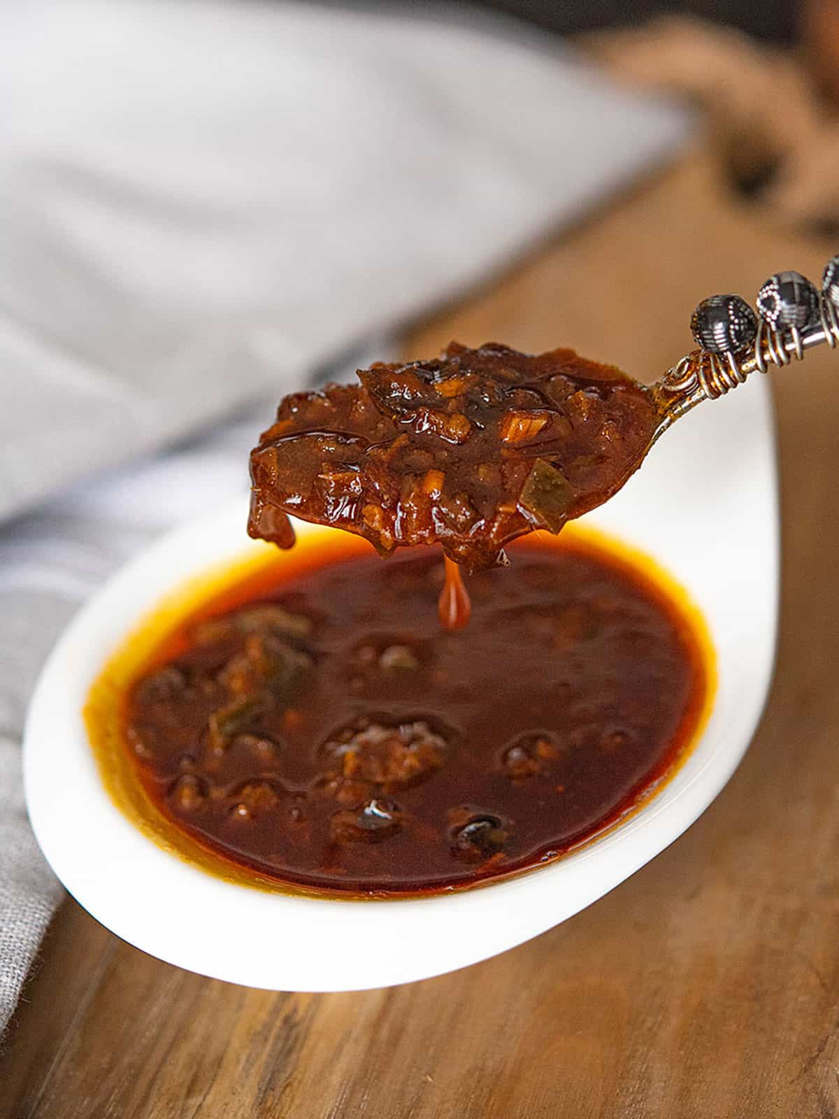 Close-up of Cajun butter sauce in a spoon with textures