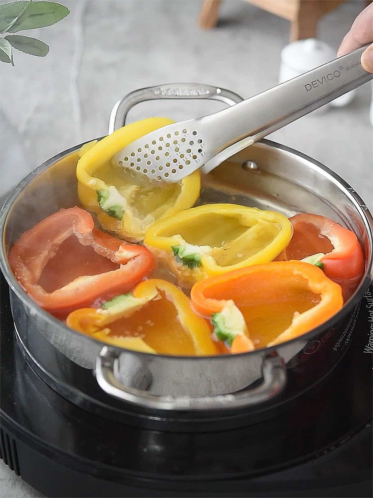 Bell peppers boiling in water before baking for chickpea stuffed peppers